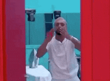a man is standing in a room with a red door and dancing .