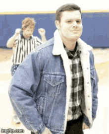 a man wearing a denim jacket with a fur collar