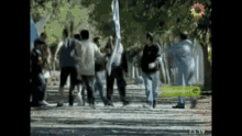 a group of people are dancing in front of a videocineg tv sign