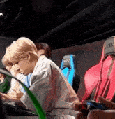 a group of people are sitting in a row in a car playing a video game .