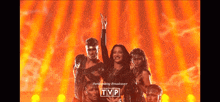 a group of people on a stage with tvp written on the bottom right