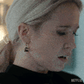 a close up of a woman 's ear with a netflix logo in the background