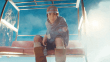 a man wearing a red bull hat sits on a chair