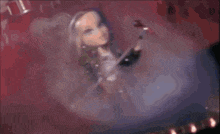 a doll with long hair is holding a microphone and a guitar