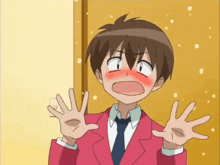 a boy in a red suit and tie is making a face