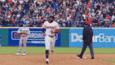 a baseball player wearing a guardians jersey runs towards home plate