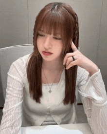 a woman with braids on her hair is sitting at a table