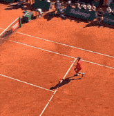 a man in a red jacket is playing tennis on a court