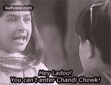 a black and white photo of a girl and a boy talking to each other in a movie .
