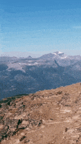a view of a mountain range from the top of a rocky hillside