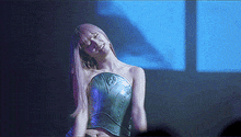 a woman wearing a green corset is dancing on a stage .