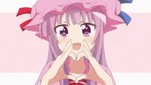 a girl with purple hair and a pink hat making a heart shape with her hands