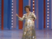 a woman in a long dress is dancing on a stage .