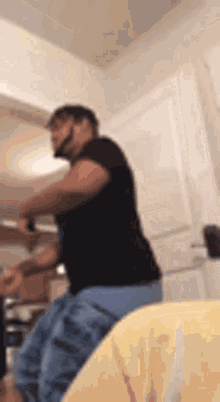 a man is standing in a kitchen with a knife in his hand and a beard .