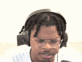 a man with dreadlocks wearing headphones and glasses