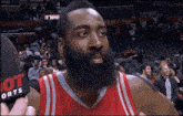 a basketball player with a beard is being interviewed by a reporter from hot sports