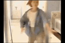 a blurry picture of a man standing in a kitchen .