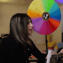 a woman sitting in front of a spinning wheel that says win
