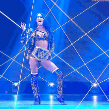 a woman in a wrestling outfit is standing on a stage holding a wrestling belt .