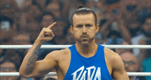 a man wearing a blue tank top that says tata