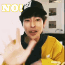 a man wearing a yellow jacket and a black hat says " no "