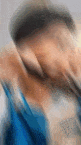 a blurry picture of a person 's face with a blue shirt