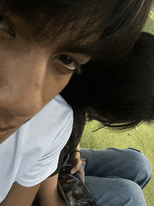 a close up of a person 's face with a phone in their hand
