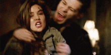 a man and a woman are standing next to each other and the woman is screaming .