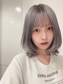 a girl with gray hair is wearing a white t-shirt that says 23kol иаiigum