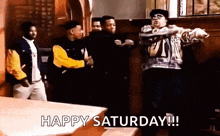 a group of men are dancing in a room with the words `` happy saturday '' written below them .