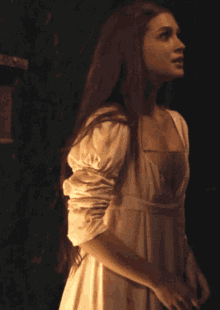 a woman with long red hair and a white dress