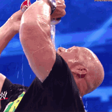 a wrestler is drinking from a can with the next thing written on it