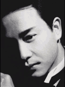 a black and white photo of a man in a tuxedo and tie