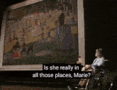 a woman in a wheelchair is sitting in front of a large painting with the caption is she really in all those places