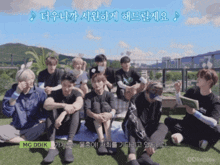 a group of young men are sitting on the grass with a green sticker that reads mc ddik