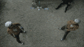 a group of people are standing in the dirt with a blue light coming out of the ground