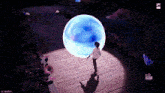 a video game screen shows a person standing in front of a glowing ball
