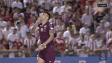 a soccer player wearing a jersey that says ' miami ' on it stands in front of a crowd