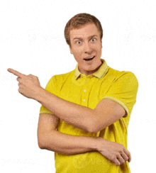 a man in a yellow shirt is pointing to the left