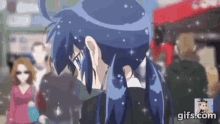 a girl with blue hair and glasses is standing in a crowded street .
