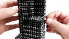 a person is holding a piece of black beads