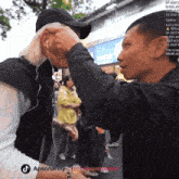 a man 's face is being touched by another man 's hand with the apponarmy logo on the bottom