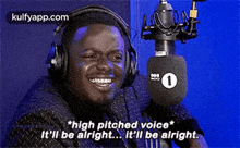 a man wearing headphones is standing in front of a microphone .