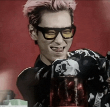 a man wearing glasses and a shirt with a skull on it is smiling