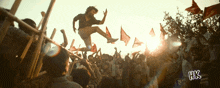 a man is jumping in the air in front of a crowd with the letters hk on the bottom right