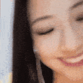 a close up of a woman 's face with her eyes closed smiling