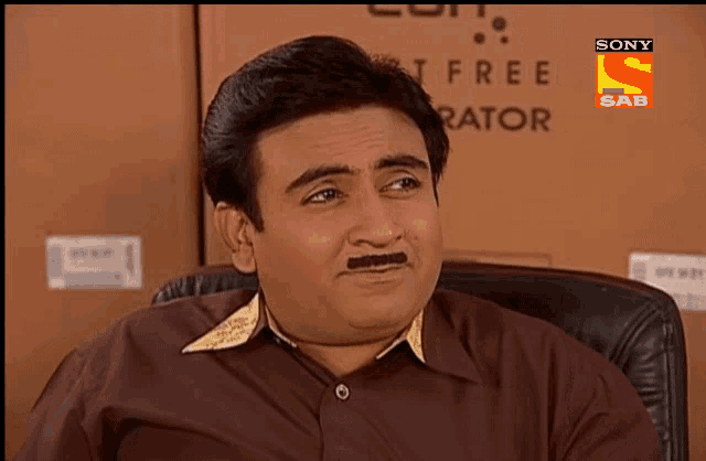 a man sitting in front of a sony sab box