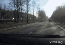 a car is driving down a road with a viralhog logo on the bottom