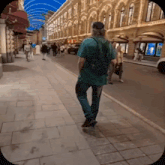 a man in a green shirt is walking down the street