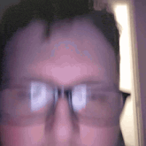 a close up of a man wearing glasses with a purple background